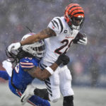 Cincinnati Bengals cornerback Cam Taylor-Britt (29) takes a hit from Buffalo Bills linebacker Tremaine Edmunds (49) during the first quarter of an NFL division round football game, Sunday, Jan. 22, 2023, in Orchard Park, N.Y. (AP Photo/Adrian Kraus)