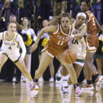 
              Texas guard Sonya Morris (11) holds off Baylor guard Sarah Andrews (24) for control of the ball in the second half of an NCAA college basketball game, Sunday, Jan. 22, 2023, in Waco, Texas. (Rod Aydelotte/Waco Tribune-Herald via AP)
            