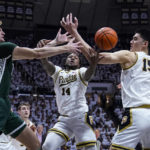 Michigan State center Carson Cooper (15) fights for a rebound with Purdue guard David Jenkins Jr. (14) and center Zach Edey (15) during the first half of an NCAA college basketball game in West Lafayette, Ind., Sunday, Jan. 29, 2023. (AP Photo/Michael Conroy)