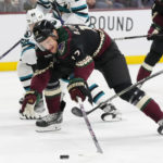 Arizona Coyotes center Nick Bjugstad (17) gets hooked by San Jose Sharks right wing Kevin Labanc (62) during the first period of an NHL hockey game in Tempe, Ariz., Tuesday, Jan. 10, 2023. (AP Photo/Ross D. Franklin)