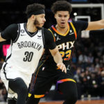 Brooklyn Nets guard Seth Curry (30) drives as Phoenix Suns forward Cameron Johnson (23) defends during the first half of an NBA basketball game, Thursday, Jan. 19, 2023, in Phoenix. (AP Photo/Matt York)
