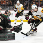 Pittsburgh Penguins right wing Rickard Rakell has his shot stopped by Arizona Coyotes goaltender Karel Vejmelka as Coyotes defenseman J.J. Moser applies pressure during the second period of an NHL hockey game in Tempe, Ariz., Sunday, Jan. 8, 2023. (AP Photo/Ross D. Franklin)