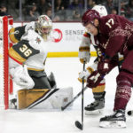 Vegas Golden Knights goaltender Logan Thompson (36) makes a save against a shot by Arizona Coyotes center Nick Bjugstad (17) as Golden Knights defenseman Alec Martinez, back right, applies pressure during the first period of an NHL hockey game in Tempe, Ariz., Sunday, Jan. 22, 2023. (AP Photo/Ross D. Franklin)