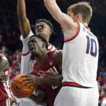 
              Washington State's TJ Banba (5) is fouled as he drives between a double-team by Arizona's Adama Bal, second from left and Azuolas Tubelis (10) during the first half of an NCAA college basketball game, Saturday, Jan. 7, 2023, in Tucson, Ariz. (AP Photo/Darryl Webb)
            