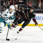 San Jose Sharks defenseman Erik Karlsson (65) passes the puck in front of Arizona Coyotes center Nick Bjugstad (17) during the first period of an NHL hockey game in Tempe, Ariz., Tuesday, Jan. 10, 2023. (AP Photo/Ross D. Franklin)