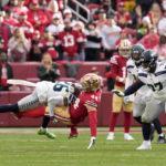 San Francisco 49ers fullback Kyle Juszczyk (44) is tackled by Seattle Seahawks safety Ryan Neal (26) as defensive tackle Poona Ford (97) looks on during the second half of an NFL wild card playoff football game in Santa Clara, Calif., Saturday, Jan. 14, 2023. (AP Photo/Godofredo A. Vásquez)