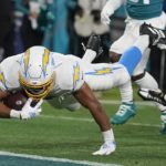 Los Angeles Chargers running back Austin Ekeler (30) leaps into the end zone after a run against the Jacksonville Jaguars during the first of an NFL wild-card football game, Saturday, Jan. 14, 2023, in Jacksonville, Fla. (AP Photo/Chris Carlson)