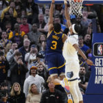 Golden State Warriors guard Jordan Poole, left, scores the game-winning basket next to Memphis Grizzlies guard Ziaire Williams during the second half of an NBA basketball game in San Francisco, Wednesday, Jan. 25, 2023. (AP Photo/Godofredo A. Vásquez)