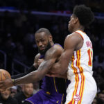 
              Los Angeles Lakers' LeBron James, left, is defended by Atlanta Hawks' De'Andre Hunter during the first half of an NBA basketball game Friday, Jan. 6, 2023, in Los Angeles. (AP Photo/Jae C. Hong)
            