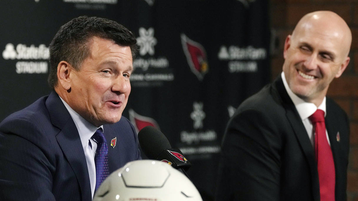Arizona Cardinals NFL football team owner Michael Bidwill, left, answers a question as Monti Ossenf...
