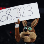 
              The Coyote, the San Antonio Spurs' mascot, helps announce the attendance at an NBA basketball game between the Spurs and the Golden State Warriors in San Antonio, Friday, Jan. 13, 2023. The announced attendance of 68,323 sets a new NBA regular-season game attendance record. (AP Photo/Eric Gay)
            