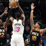 Miami Heat center Bam Adebayo (13) shoots against Phoenix Suns center Deandre Ayton (22) and guard Damion Lee (10) during the second half of an NBA basketball game in Phoenix, Friday, Jan. 6, 2023. The Heat won 104-96. (AP Photo/Ross D. Franklin)