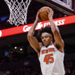 New York Knicks center  Jericho Sims (45) grabs a rebound against the Toronto Raptors during the first half of an NBA basketball game Friday, Jan. 6, 2023, in Toronto. (Cole Burston/The Canadian Press via AP)