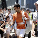 
              Serbia's Novak Djokovic (right) and Canada's Vasek Pospisil with fans before his doubles match during their Round of 32 match at the Adelaide International Tennis tournament in Adelaide, Australia, Monday, Jan. 2, 2023. (AP Photo/Kelly Barnes)
            