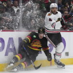Vancouver Canucks' Sheldon Dries, left, and Chicago Blackhawks' Seth Jones collide during the third period of an NHL hockey game Tuesday, Jan. 24, 2023, in Vancouver, British Columbia. (Darryl Dyck/The Canadian Press via AP)