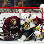 Arizona Coyotes goaltender Karel Vejmelka, left, makes a save against a shot by Vegas Golden Knights center Byron Froese (51) as Coyotes defenseman Troy Stecher, second from right, and Golden Knights right wing Keegan Kolesar (55) look on during the third period of an NHL hockey game in Tempe, Ariz., Sunday, Jan. 22, 2023. (AP Photo/Ross D. Franklin)