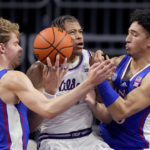
              Kansas guard Gradey Dick (4) and forward Jalen Wilson, right, try to steal the ball from Kansas State forward Keyontae Johnson (11) during the first half of an NCAA college basketball game Tuesday, Jan. 17, 2023, in Manhattan, Kan. (AP Photo/Charlie Riedel)
            