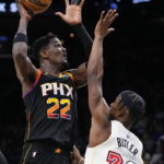 Phoenix Suns center Deandre Ayton (22) shoots over Miami Heat forward Jimmy Butler during the second half of an NBA basketball game in Phoenix, Friday, Jan. 6, 2023. The Heat won 104-96. (AP Photo/Ross D. Franklin)