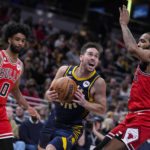 
              Indiana Pacers guard T.J. McConnell (9) cuts between Chicago Bulls guard Coby White (0) and forward Derrick Jones Jr. (5) during the first half of an NBA basketball game in Indianapolis, Tuesday, Jan. 24, 2023. (AP Photo/Michael Conroy)
            