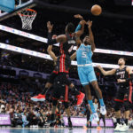 Charlotte Hornets center Mark Williams (5) and Miami Heat guard Victor Oladipo (4) battle for a rebound during the first half of an NBA basketball game in Charlotte, N.C., Sunday, Jan. 29, 2023. (AP Photo/Nell Redmond)