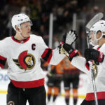 Ottawa Senators defenseman Artem Zub, right, celebrates after his empty-net goal against the Arizona Coyotes with left wing Brady Tkachuk, left, during the third period of an NHL hockey game in Tempe, Ariz., Thursday, Jan. 12, 2023. (AP Photo/Ross D. Franklin)