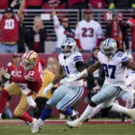 San Francisco 49ers quarterback Brock Purdy (13) scrambles away from Dallas Cowboys linebacker Micah Parsons (11) and defensive tackle Osa Odighizuwa (97) during the first half of an NFL divisional round playoff football game in Santa Clara, Calif., Sunday, Jan. 22, 2023. (AP Photo/Tony Avelar)