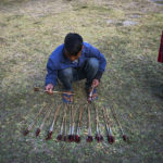 
              A man sorts arrows after the first round of an archery event in Shillong, India, Monday, Jan. 16, 2023. Each afternoon, except on Sundays and public holidays, this event takes place in a small field and people place bets on the results. (AP Photo/Ashwini Bhatia)
            