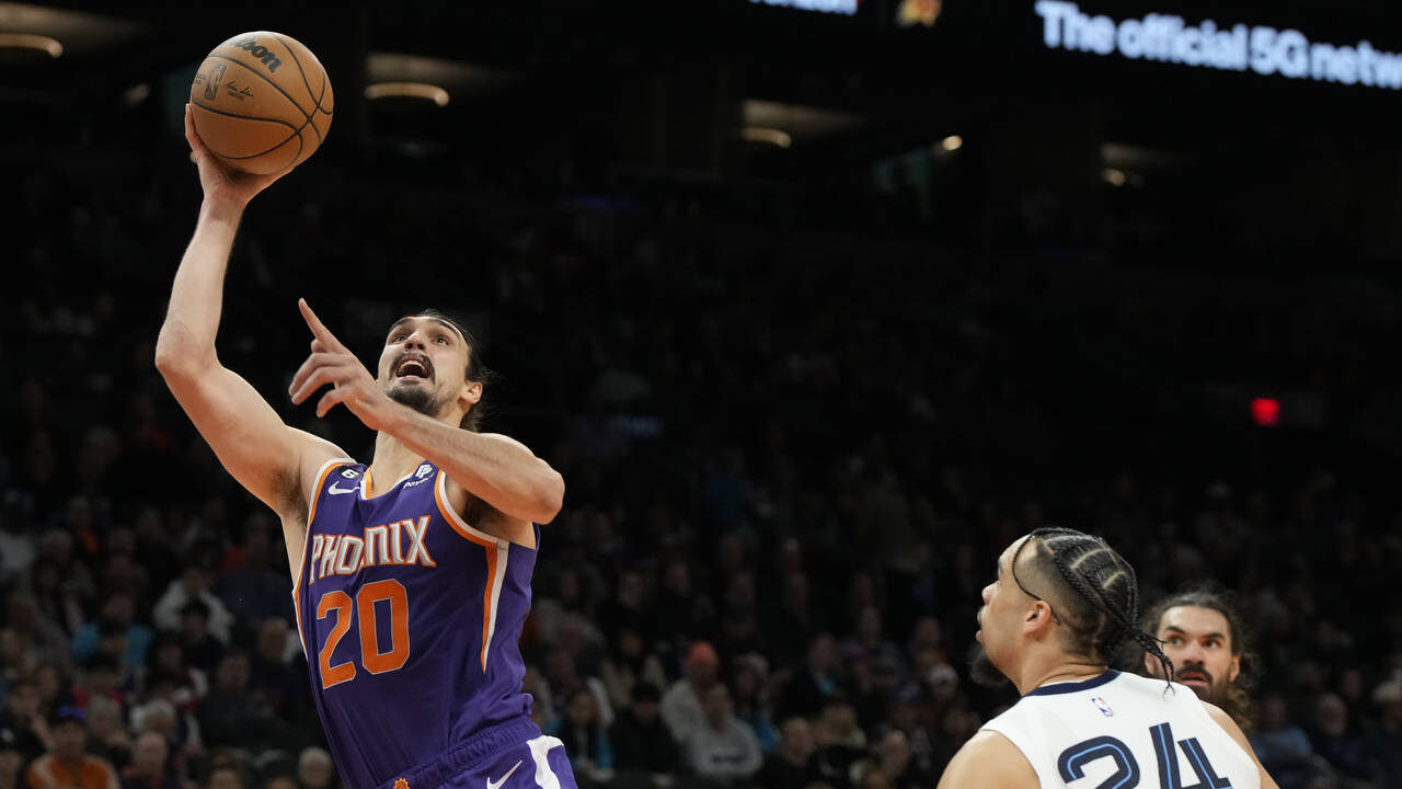 Phoenix Suns forward Dario Saric (20) drives past Memphis Grizzlies forward Dillon Brooks (24) duri...