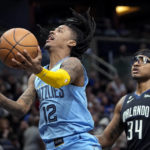 Memphis Grizzlies' Ja Morant (12) looks to shoot as he gets in front of Orlando Magic's Wendell Carter Jr. (34) during the second half of an NBA basketball game, Thursday, Jan. 5, 2023, in Orlando, Fla. (AP Photo/John Raoux)