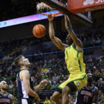 Oregon center N'Faly Dante (1) dunks as Arizona forward Azuolas Tubelis watches during the first half of an NCAA college basketball game Saturday, Jan. 14, 2023, in Eugene, Ore. (AP Photo/Andy Nelson)