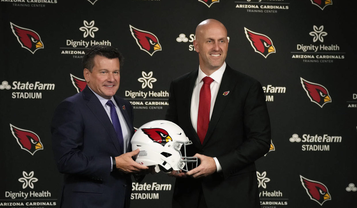 Arizona Cardinals NFL football team owner Michael Bidwill, left, and Monti Ossenfort, right, hold a...