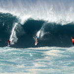 
              Kai Lenny, left, and Aaron Gold, center, are cheered on by Jake Maki, right, in Hawaii's Waimea Bay on Oahu’s North Shore during the The Eddie Aikau Big Wave Invitational surfing contest Sunday, Jan. 22, 2023. (Jamm Aquino/Honolulu Star-Advertiser via AP)
            