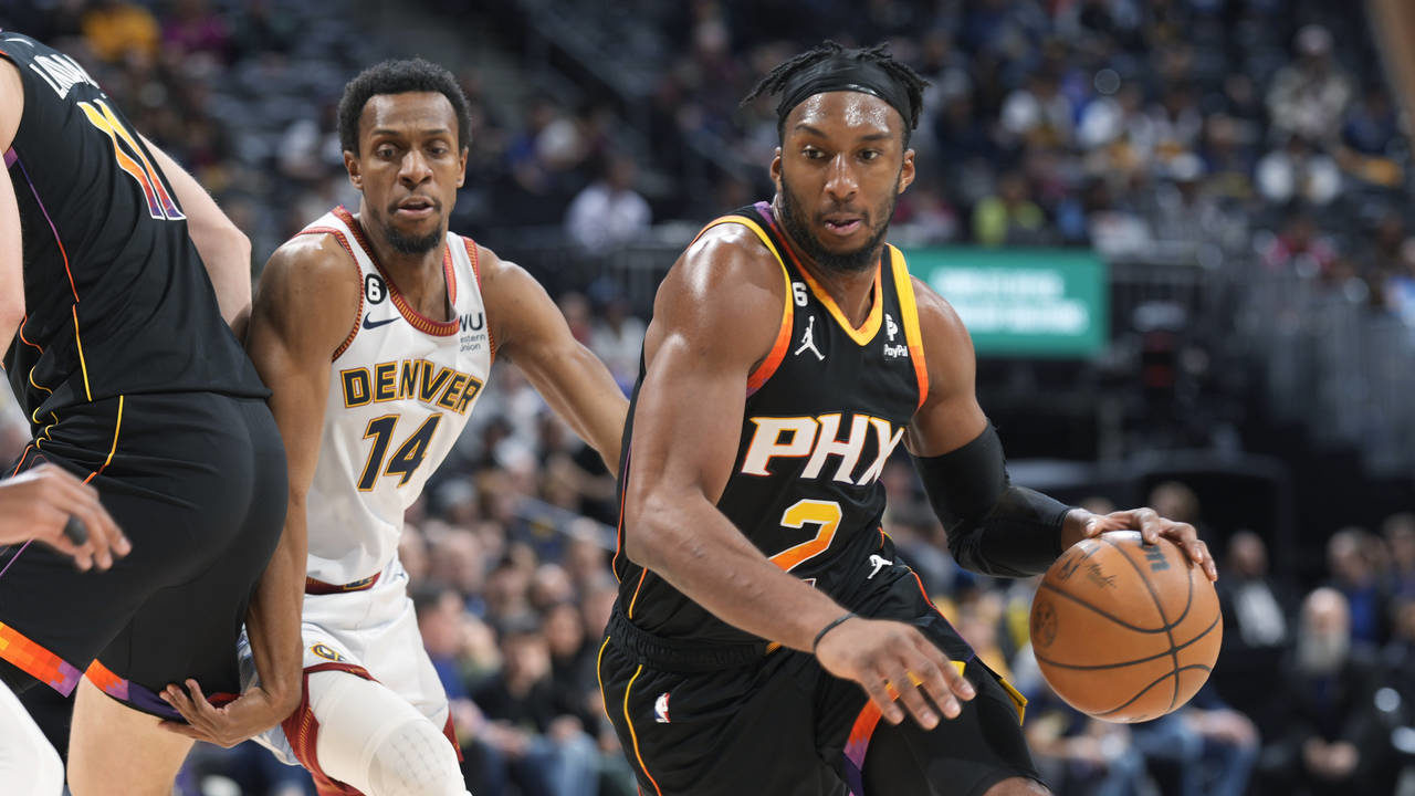 Phoenix Suns forward Josh Okogie drives as Denver Nuggets guard Ish Smith works around a screen dur...