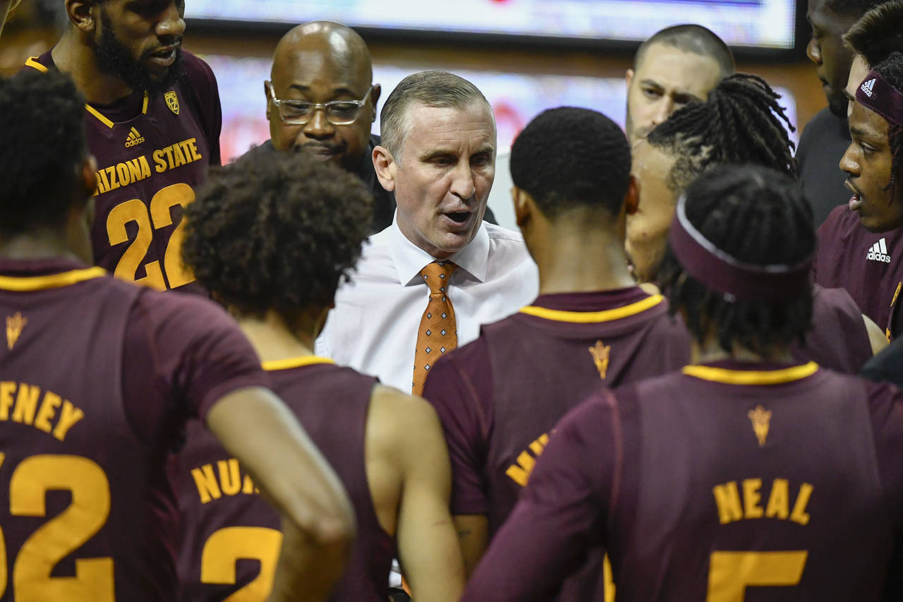 Arizona State head coach Bobby Hurley, center, talks with his players during a timeout during the f...