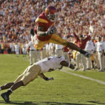 
              FILE - Southern California's Reggie Bush leaps over UCLA defender Marcus Cassel as he rushes 13 yards for a touchdown in the second quarter of an NCAA college football game at the Los Angeles Memorial Coliseum, Saturday, Dec. 3, 2005. Reggie Bush, whose Heisman Trophy victory for Southern California in 2005 was vacated because of NCAA violations, was among 18 players in the latest College Football Hall of Fame class announced Monday, Jan. 9, 2023. (AP Photo/Chris Carlson, File)
            