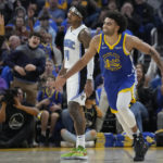 Golden State Warriors forward Anthony Lamb (40) reacts after making a 3-point basket in front of Orlando Magic guard Gary Harris (14) during the first half of an NBA basketball game in San Francisco, Saturday, Jan. 7, 2023. (AP Photo/Jeff Chiu)
