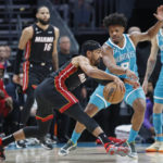 
              Miami Heat guard Gabe Vincent (2) keeps the ball from Charlotte Hornets guard Dennis Smith Jr. (8) during the first half of an NBA basketball game in Charlotte, N.C., Sunday, Jan. 29, 2023. (AP Photo/Nell Redmond)
            