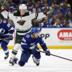 Minnesota Wild left wing Matt Boldy (12) takes down Tampa Bay Lightning left wing Brandon Hagel (38) during the second period of an NHL hockey game Tuesday, Jan. 24, 2023, in Tampa, Fla. (AP Photo/Chris O'Meara)