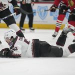 Arizona Coyotes left wing Michael Carcone falls on the ice while chasing the puck during the third period of an NHL hockey game against the Chicago Blackhawks, Friday, Jan. 6, 2023, in Chicago. (AP Photo/Erin Hooley)