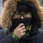 
              A commuter wearing a face mask walks along a street in the central business district in Beijing, Thursday, Jan. 12, 2023. (AP Photo/Mark Schiefelbein)
            