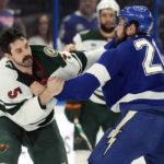 Minnesota Wild defenseman Jake Middleton (5) and Tampa Bay Lightning left wing Nicholas Paul (20) fight during the first period of an NHL hockey game Tuesday, Jan. 24, 2023, in Tampa, Fla. (AP Photo/Chris O'Meara)