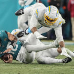 Jacksonville Jaguars quarterback Trevor Lawrence (16) is sacked against the Los Angeles Chargers during the second half of an NFL wild-card football game, Saturday, Jan. 14, 2023, in Jacksonville, Fla. The Los Angeles Chargers were called for a penalty voiding the sack. (AP Photo/Chris Carlson)