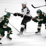 Arizona Coyotes center Barrett Hayton (29) reaches for the puck with defense from Minnesota Wild defenseman Jonas Brodin (25) and center Frederick Gaudreau (89) in the third period during an NHL hockey game Saturday, Jan. 14, 2023, in St. Paul, Minn. (AP Photo/Andy Clayton-King)