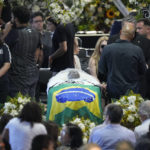 
              The coffin with the remains of Brazilian soccer great Pele lies in state during his wake on the pitch of the Vila Belmiro stadium in Santos, Brazil, Monday, Jan. 2, 2023. (AP Photo/Andre Penner)
            