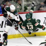 Minnesota Wild center Sam Steel (13) is tripped up by Arizona Coyotes defenseman Patrik Nemeth (2) in the first period during an NHL hockey game Saturday, Jan. 14, 2023, in St. Paul, Minn. (AP Photo/Andy Clayton-King)