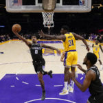 
              Sacramento Kings guard Malik Monk (0) shoots against Los Angeles Lakers center Thomas Bryant (31) during the first half of an NBA basketball game in Los Angeles, Wednesday, Jan. 18, 2023. (AP Photo/Ashley Landis)
            