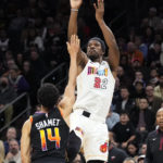 Miami Heat forward Jimmy Butler (22) shoots over Phoenix Suns guard Landry Shamet (14) during the first half of an NBA basketball game in Phoenix, Friday, Jan. 6, 2023. (AP Photo/Ross D. Franklin)