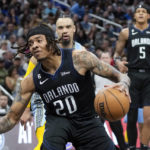 
              Orlando Magic's Markelle Fultz (20) looks for a path to the basket as Memphis Grizzlies' Dillon Brooks defends during the first half of an NBA basketball game, Thursday, Jan. 5, 2023, in Orlando, Fla. (AP Photo/John Raoux)
            