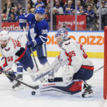 Toronto Maple Leafs defenseman Rasmus Sandin (38) looks for a rebound as Washington Capitals defenseman Erik Gustafsson (56) tries to clear the puck in front of goaltender Darcy Kuemper (35) during the second period of an NHL hockey game in Toronto on Sunday, Jan. 29, 2023. (Cole Burston/The Canadian Press via AP)
