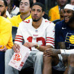 Injuried Indiana Pacers' Tyrese Haliburton wears a San Francisco 49ers' Brock Prudy jersey while eating popcorn during the second half of the team's NBA basketball game against the Phoenix Suns in Phoenix, Saturday, Jan. 21, 2023. Haliburton and Purdy both went to Iowa State. (AP Photo/Darryl Webb)